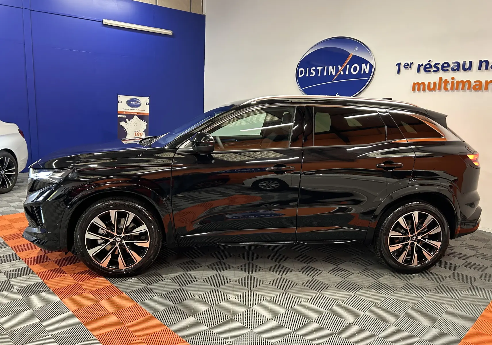 Profil côté gauche du Renault Austral Ph.2 E-TECH full hybrid 200 TECHNO noir étoilé en showroom avec jantes bi-ton.