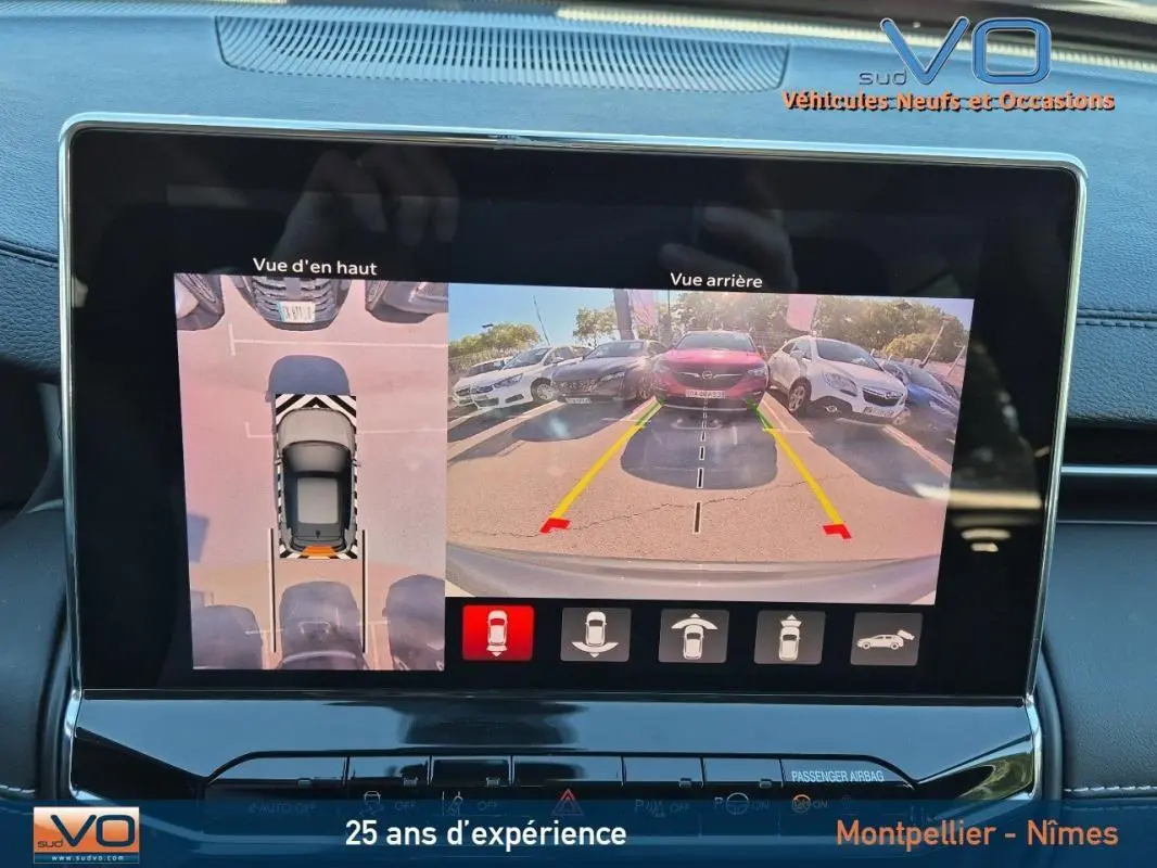 Écran tactile du Jeep Compass gris 2024 montrant la caméra de recul et la vue aérienne du stationnement.