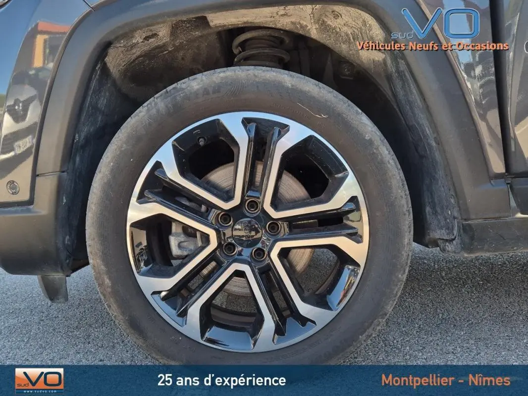 Gros plan sur la jante alliage 18 pouces noire et argent du Jeep Compass gris 2024 côté arrière droit.