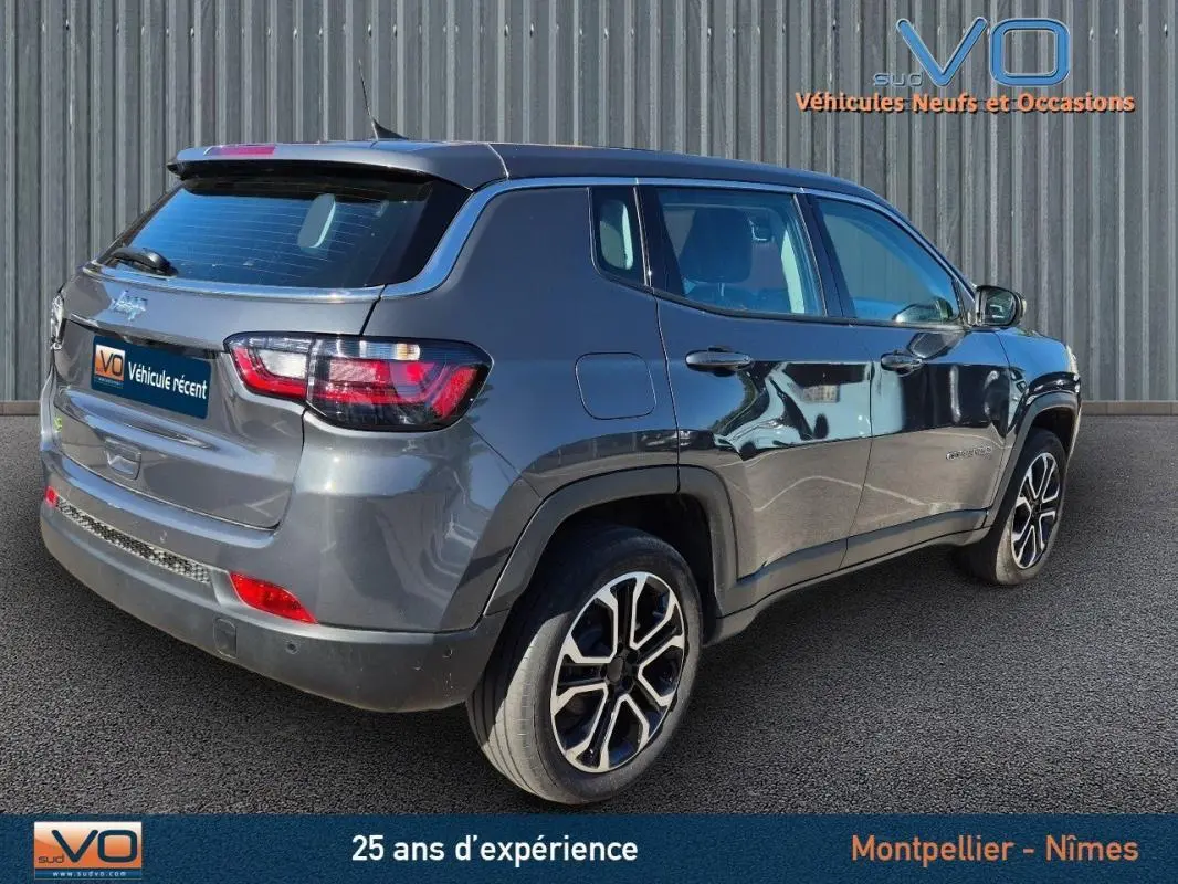 Vue 3/4 arrière droite d'un Jeep Compass gris 2024 avec jantes alliage 18 pouces et vitres teintées.