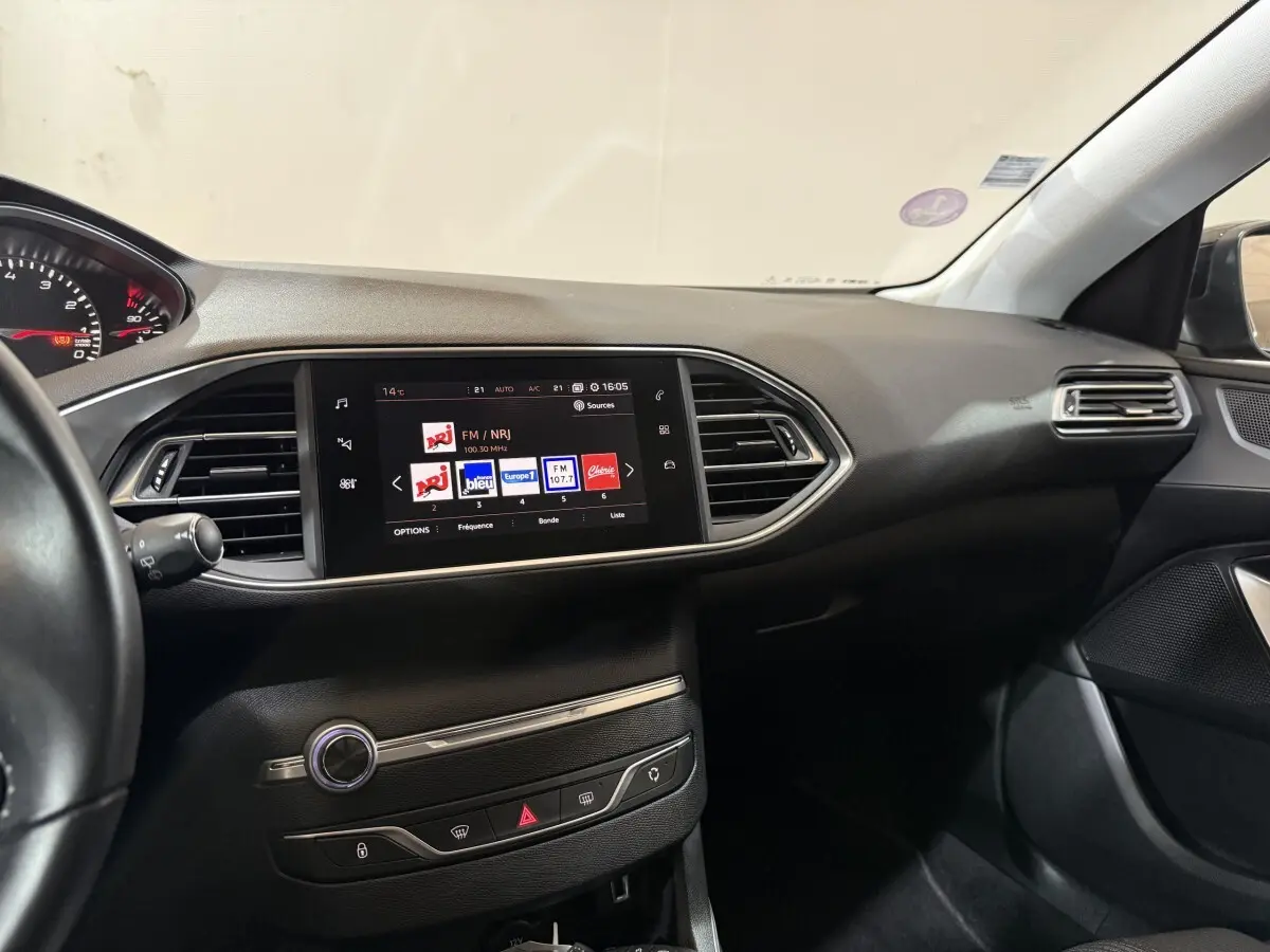 Tableau de bord noir de Peugeot 308 Puretech 130 vu côté passager avec écran tactile central allumé