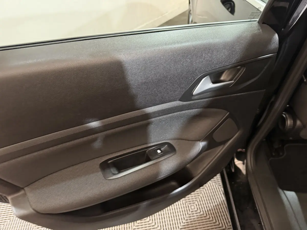 Gros plan sur la porte arrière droite noire de la Peugeot 308 2020, avec poignée intérieure et commande de vitre visible.