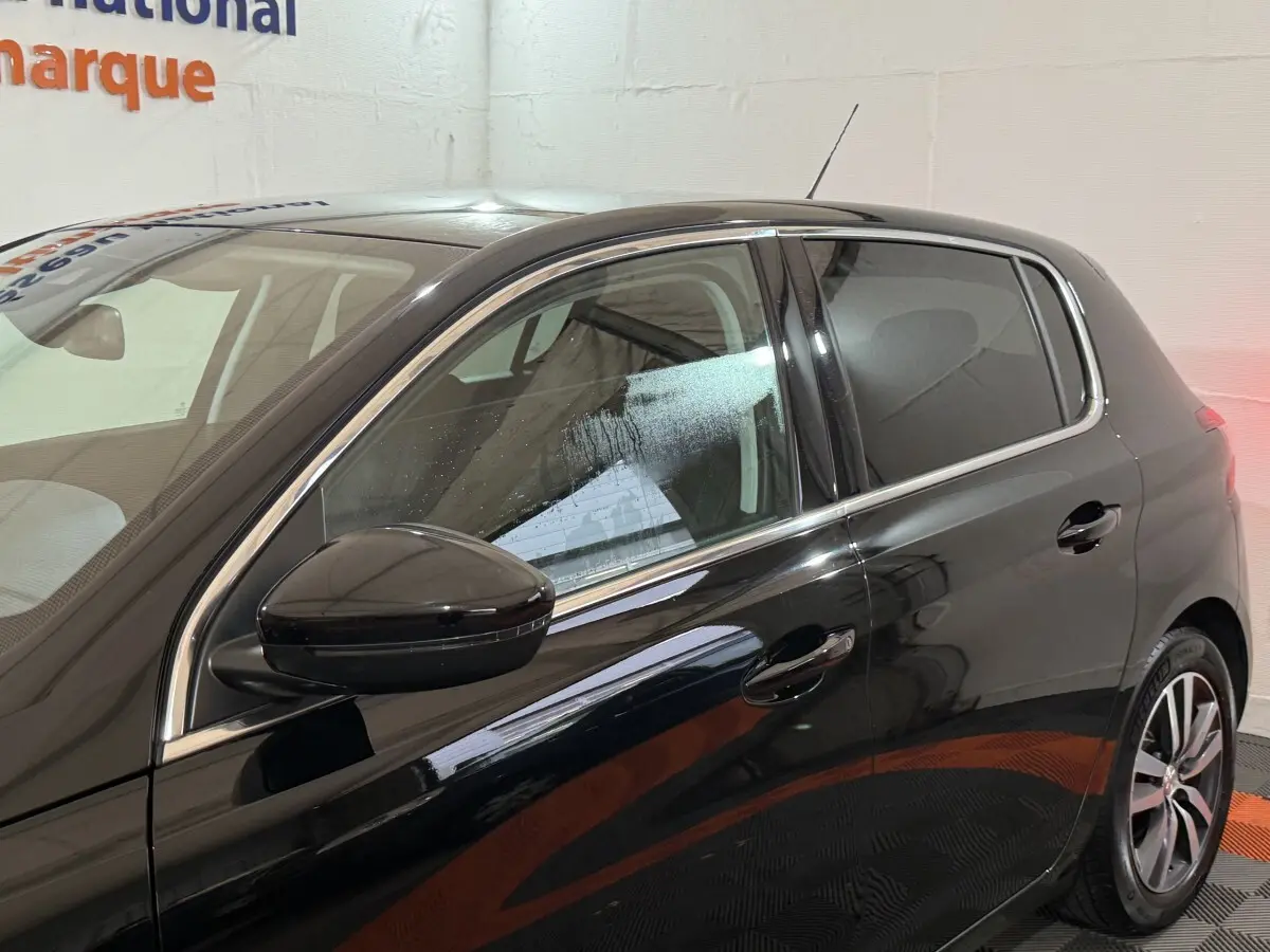 Vue latérale gauche d'une Peugeot 308 noire de 2020, mettant en valeur la finition brillante et les jantes alliage.