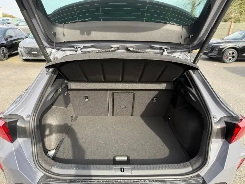 Coffre ouvert vu de l'arrière d'une CUPRA Formentor 2.0 TDI gris Graphène personnalisé, espace de chargement vide et propre.