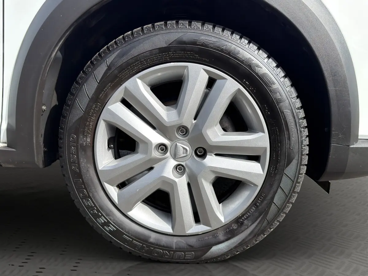 Gros plan sur la roue avant droite d'une Dacia Sandero Stepway blanche, avec jante alliage grise et pneu Falken.