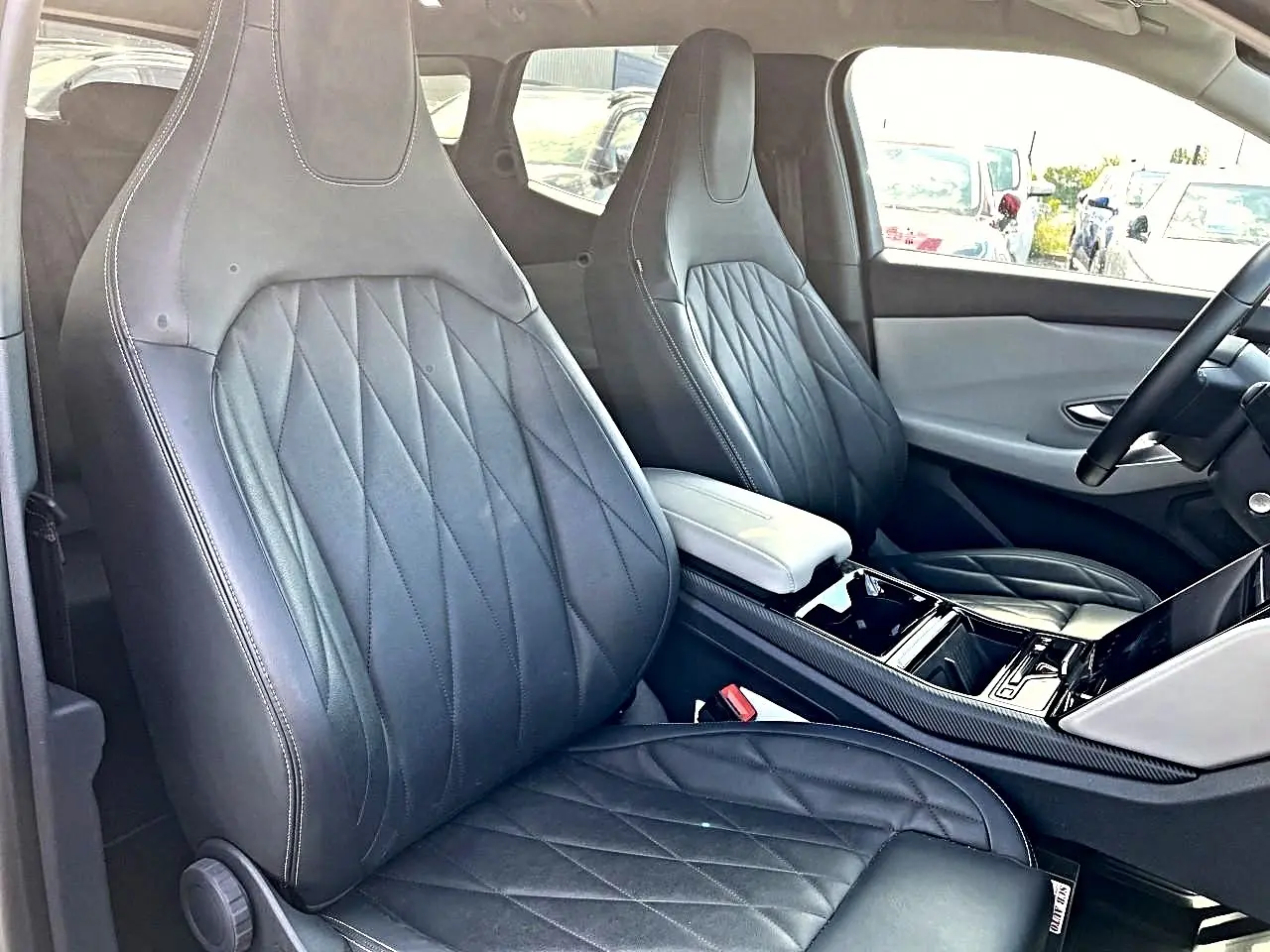 Vue intérieure côté avant droit du Ford Explorer 2025 gris, mettant en valeur les sièges en cuir noir et la console centrale.