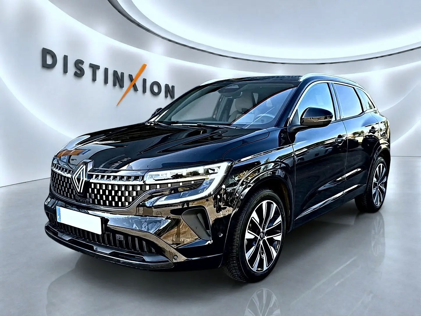 Renault Austral noir en 3/4 avant droit, avec calandre distinctive et jantes alliage visibles en showroom lumineux.