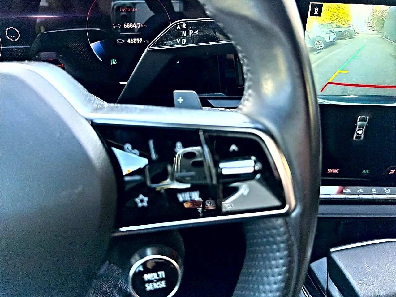 Gros plan sur le volant noir multifonction et l'écran tactile affichant la caméra de recul du Renault Austral 2023.