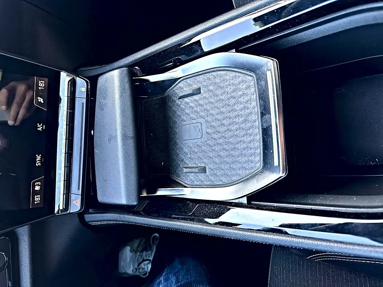 Vue plongeante sur la console centrale noire du Renault Austral 2023 avec accoudoir et espace de rangement fermé.