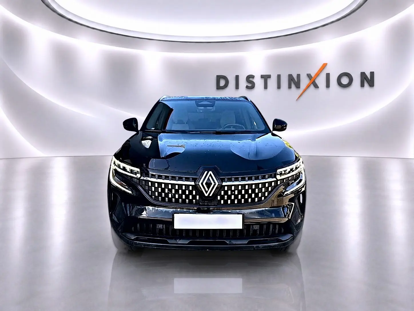 Vue avant d'un Renault Austral noir brillant avec calandre à motifs lumineux dans un showroom épuré.