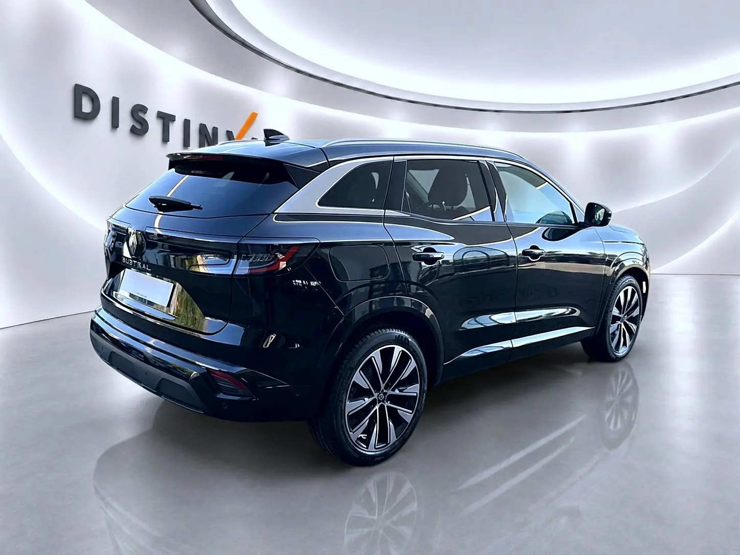 Renault Austral noir en 3/4 arrière droit, jantes alliage et vitres arrière surteintées visibles dans un showroom lumineux.