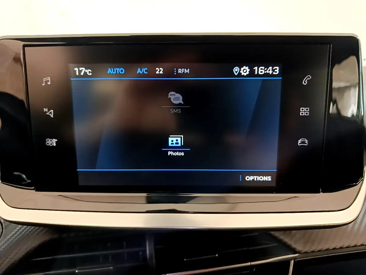 Écran tactile central du tableau de bord du Peugeot 2008 gris foncé, affichant les options multimédia et climatisation.