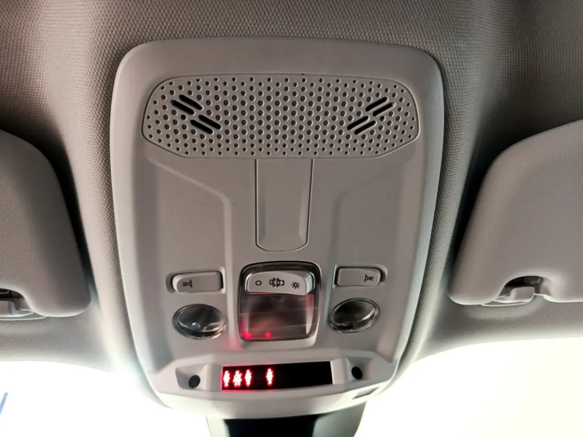 Plafonnier intérieur avec commandes d'éclairage et alertes, Peugeot 2008 gris foncé, vue vers le toit depuis l'habitacle.