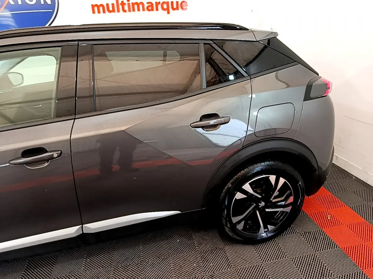 Vue côté droit arrière du Peugeot 2008 gris foncé, avec jantes alliage noires et toit noir contrastant.