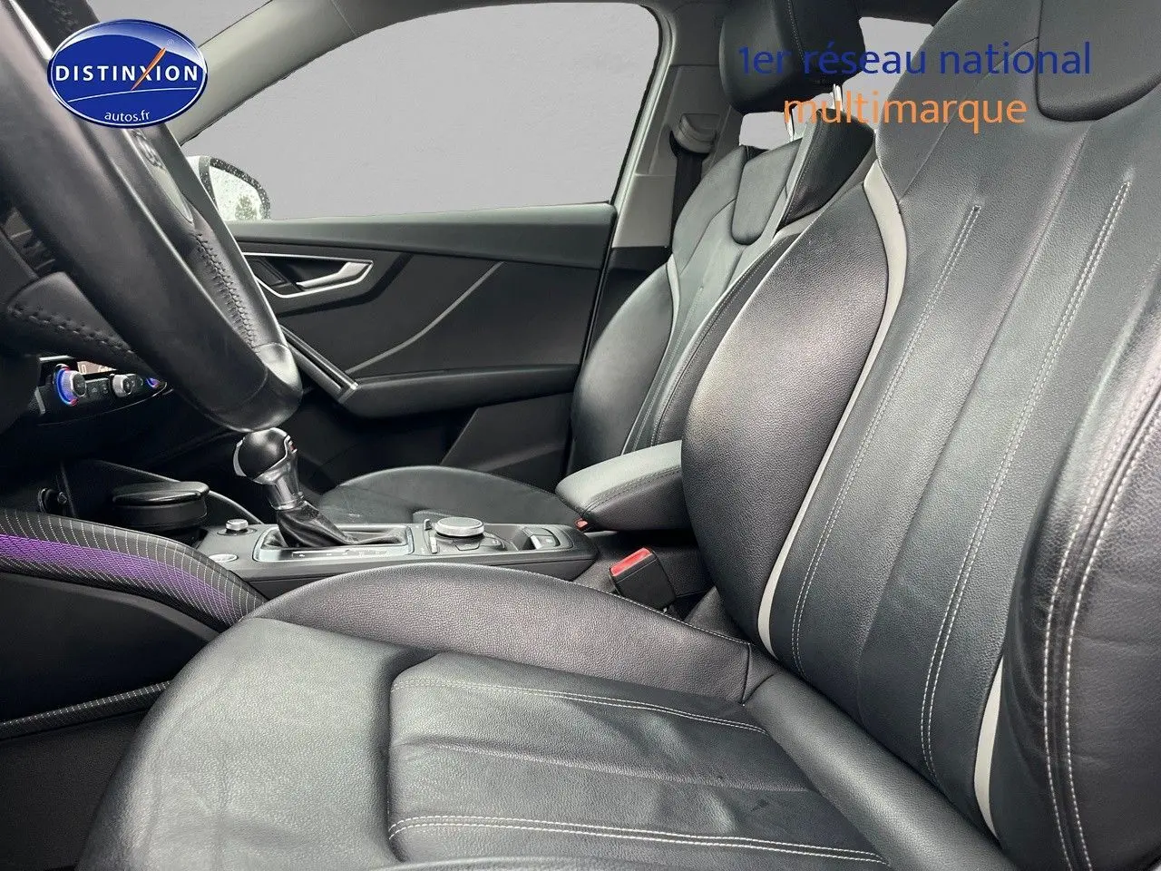 Vue intérieure côté conducteur de l'Audi Q2 2018 avec sièges cuir noir et console centrale équipée.
