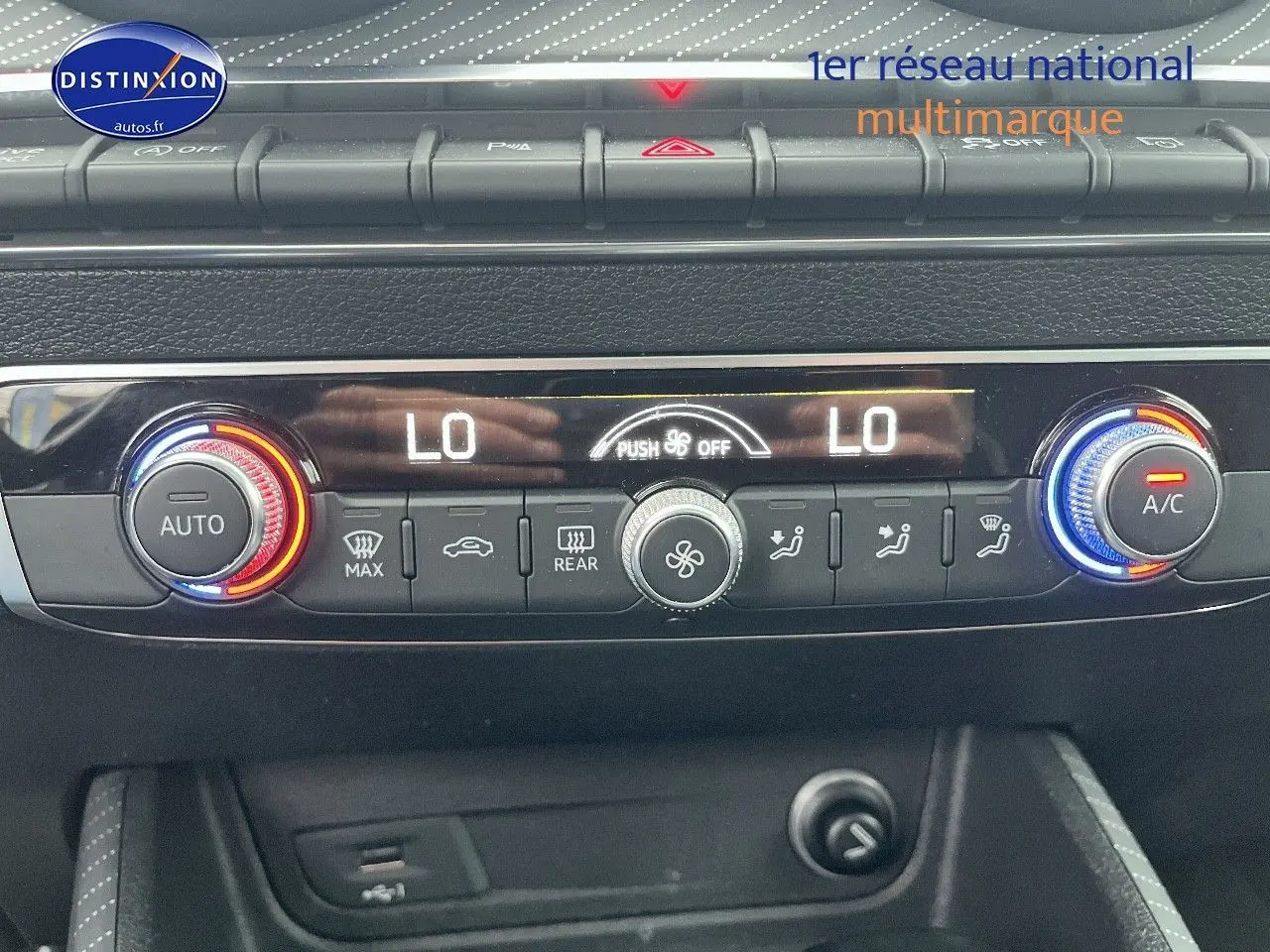 Gros plan sur la console de climatisation automatique de l'Audi Q2 avec réglages température et ventilation affichés.