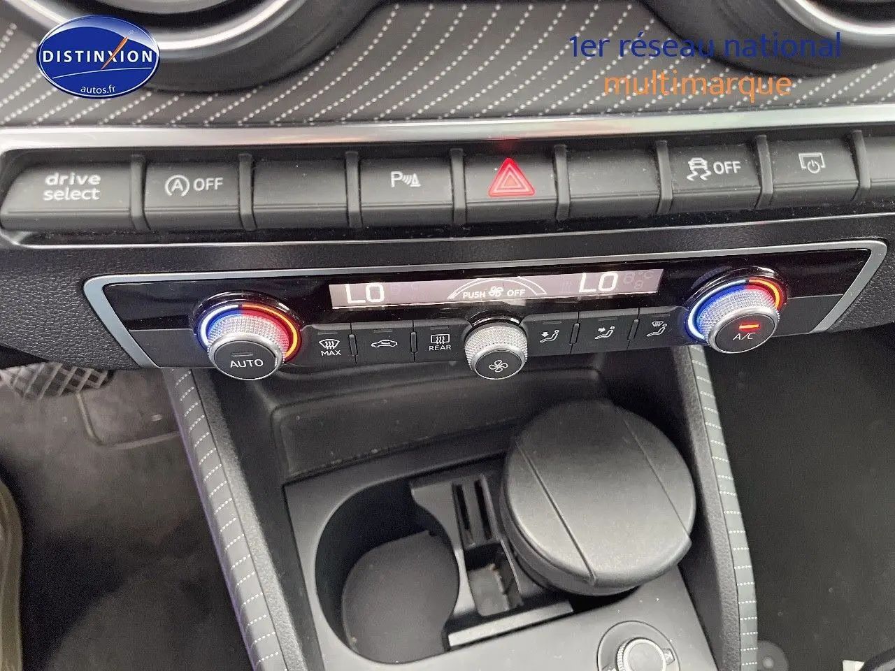 Vue rapprochée du tableau de bord et console centrale de l'Audi Q2 2018 avec commandes climatisation et rangements.