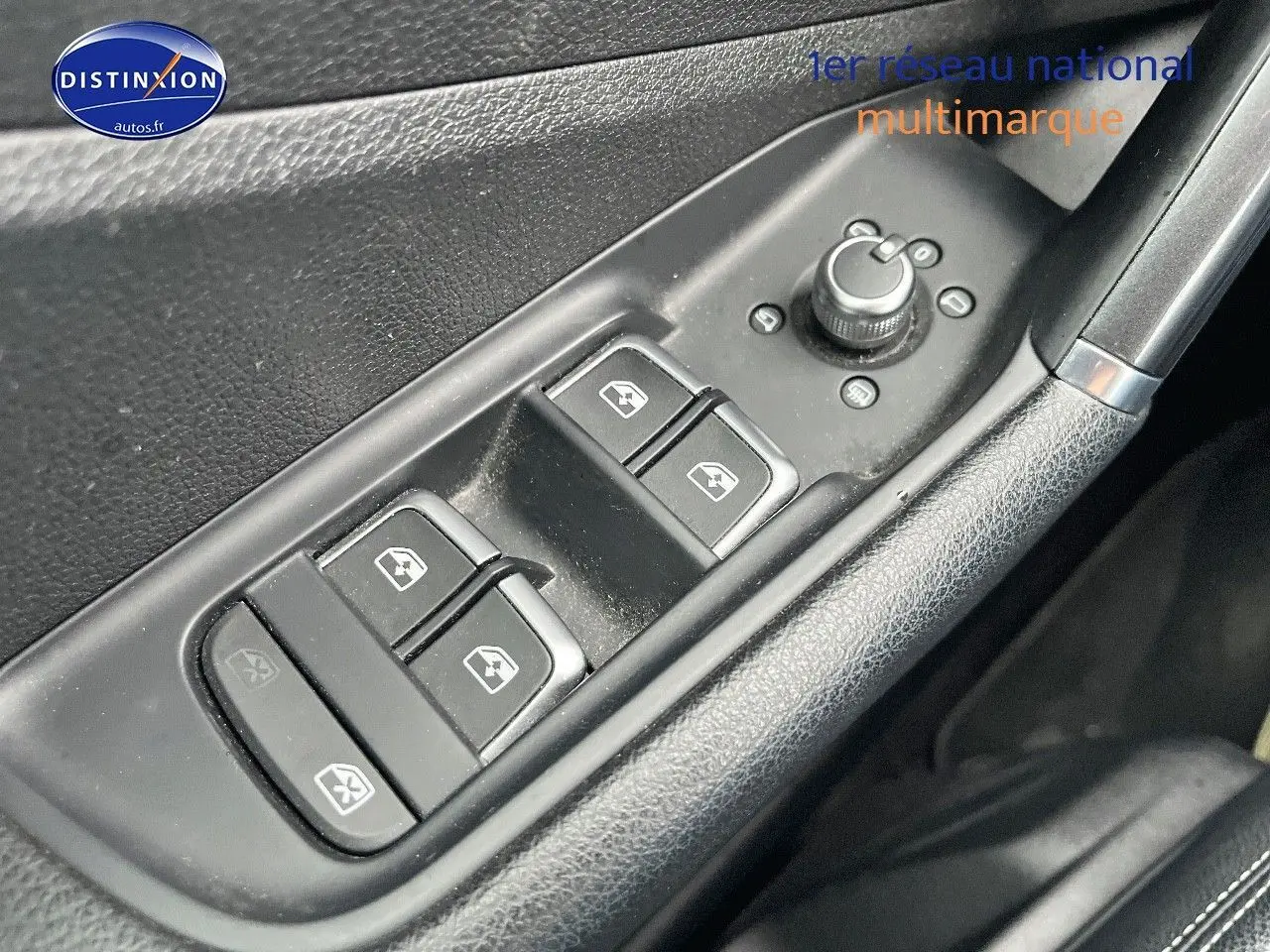 Gros plan sur les commandes de lève-vitres et rétroviseurs côté conducteur d’un Audi Q2 2018 intérieur noir.