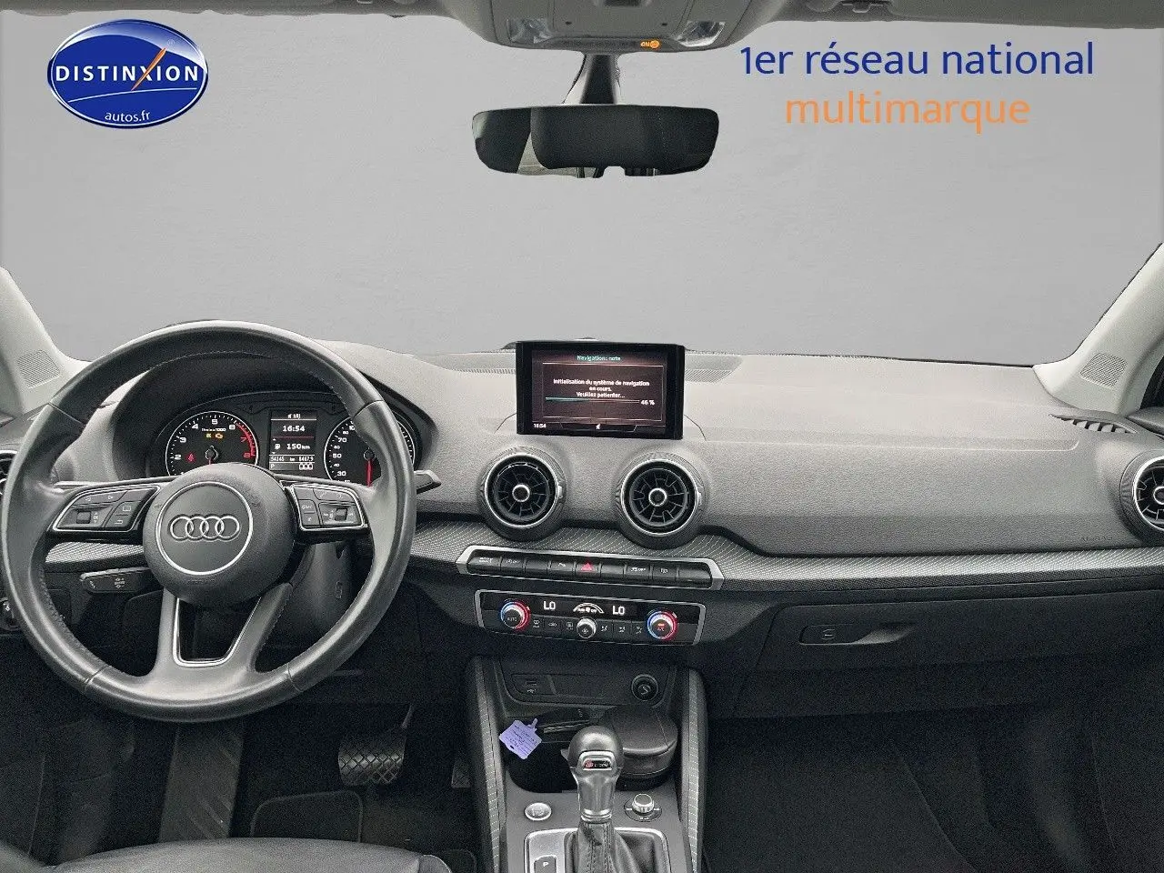 Vue intérieure avant de l'Audi Q2 2018 avec tableau de bord noir, volant cuir multifonction et écran central intégré.