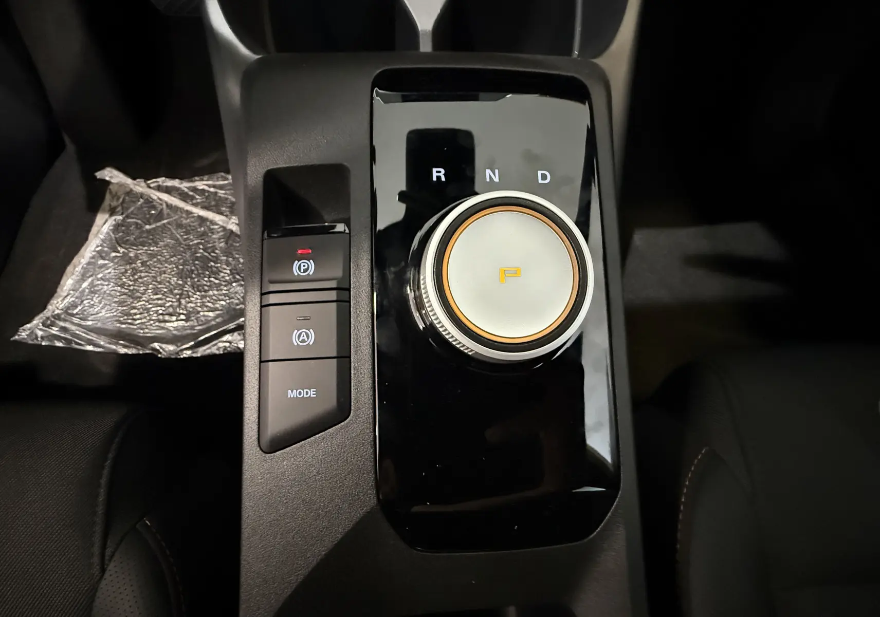 Gros plan sur la molette de boîte automatique et les boutons de mode et frein à main du MG3 Cosmic Silver, intérieur noir.