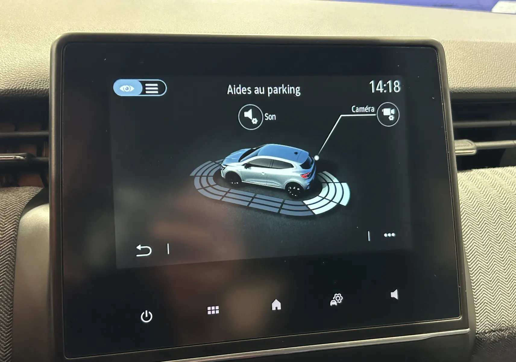 Écran tactile intérieur montrant l’aide au parking avec une illustration 3D d’une Renault Clio V gris rafale métal.