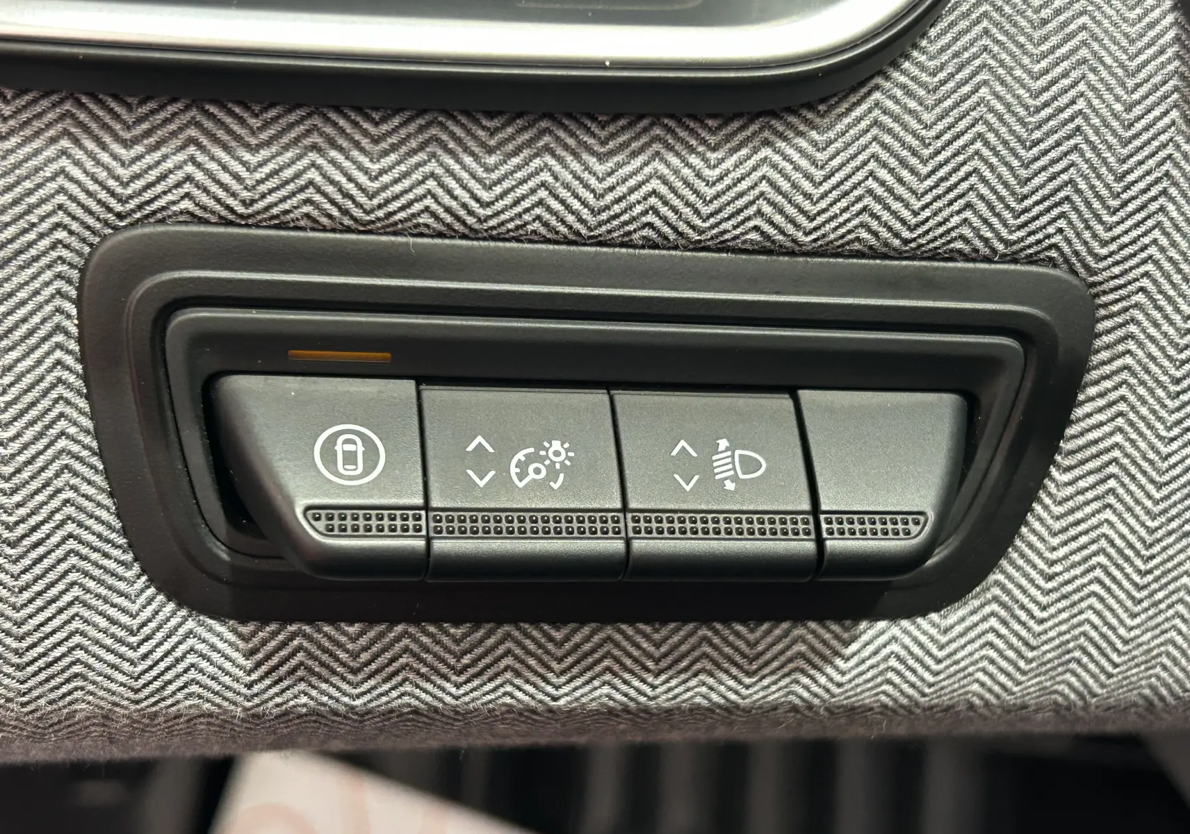 Gros plan sur les commandes de réglage d’éclairage et verrouillage dans l’habitacle gris noir de la Renault Clio V E-Tech Hybrid.