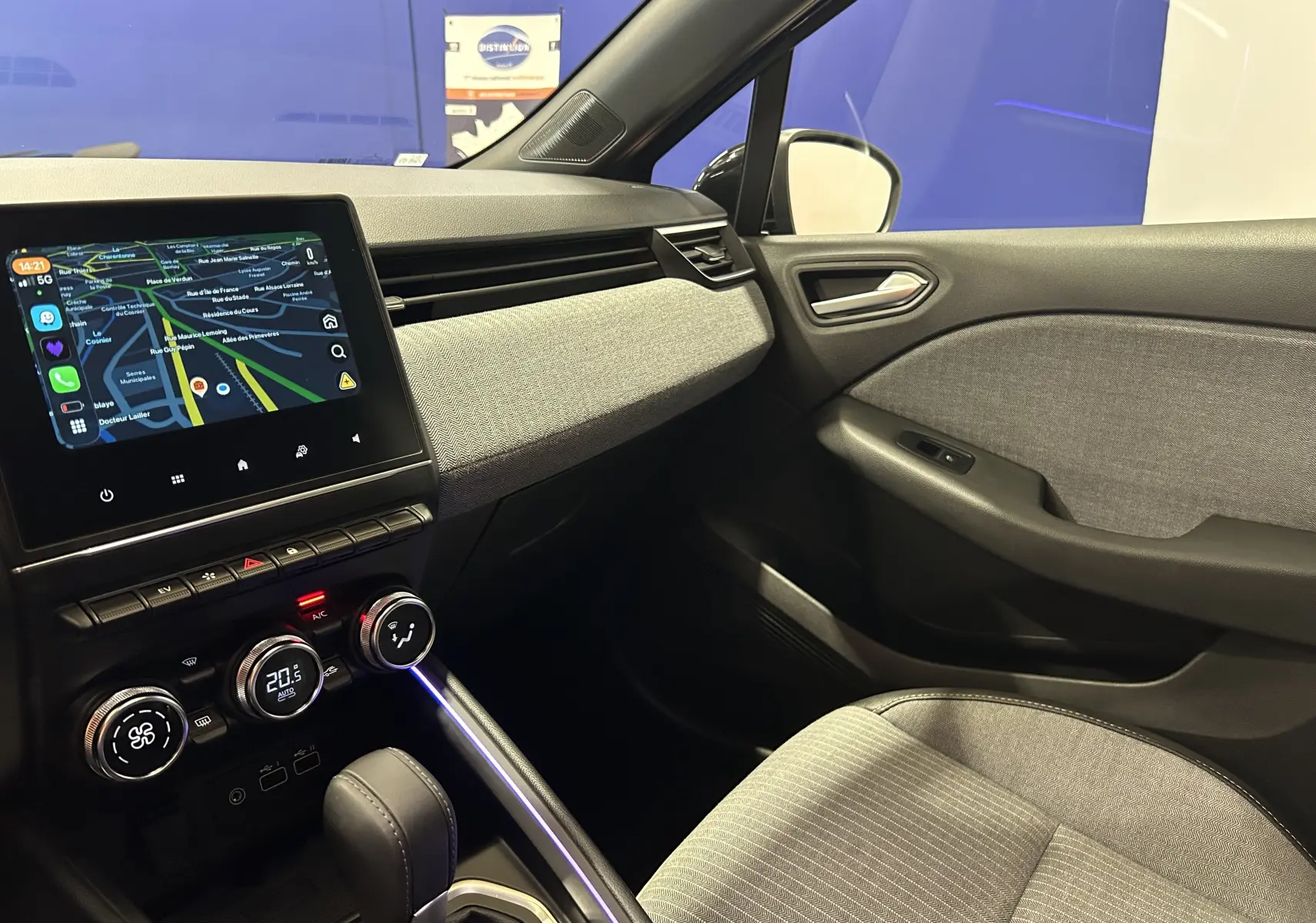 Intérieur côté passager de la Renault Clio V E-Tech gris rafale, avec écran tactile GPS et console centrale moderne.