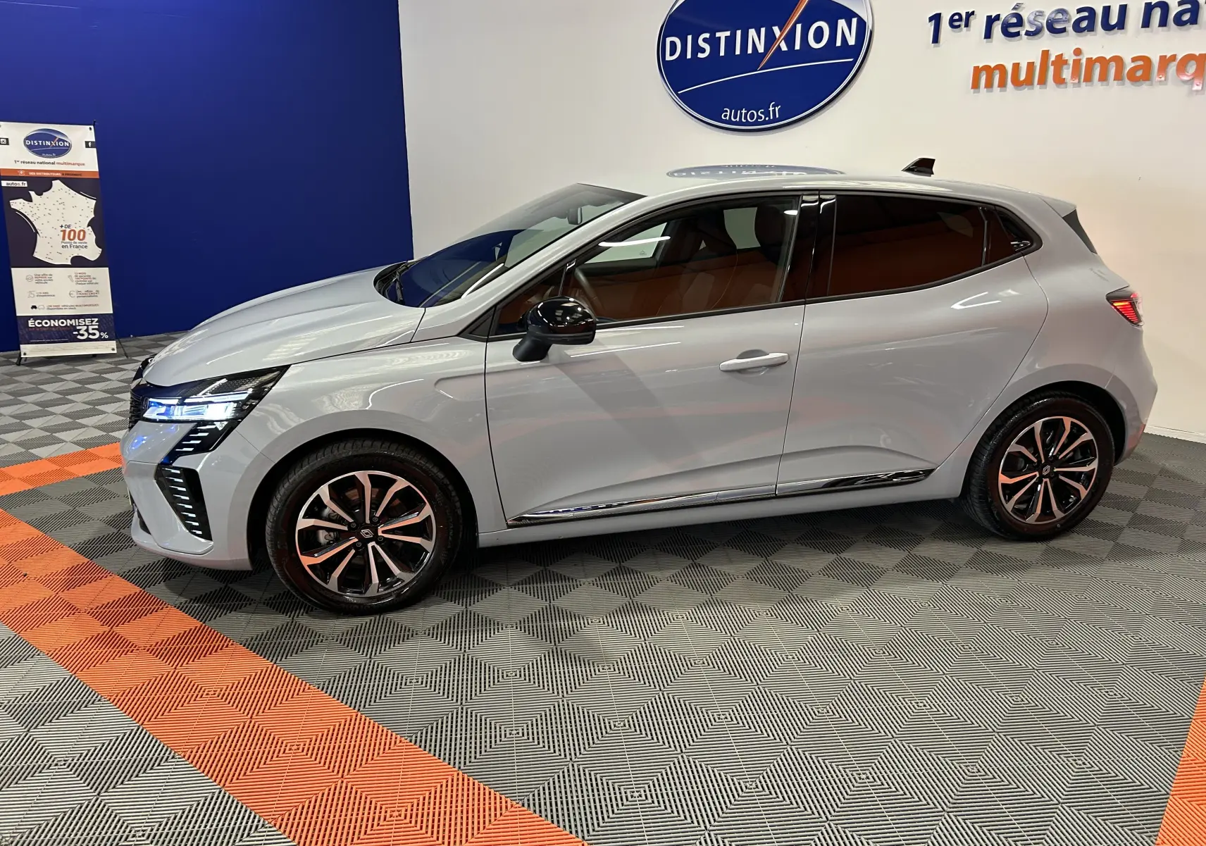 Renault Clio V E-Tech gris Rafale métal vue de profil côté gauche, avec jantes alliage et vitres teintées.