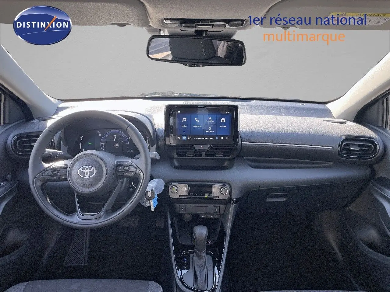 Intérieur de la Toyota Yaris Hybrid 2025 en noir, vue frontale du tableau de bord avec écran tactile et volant multifonction.
