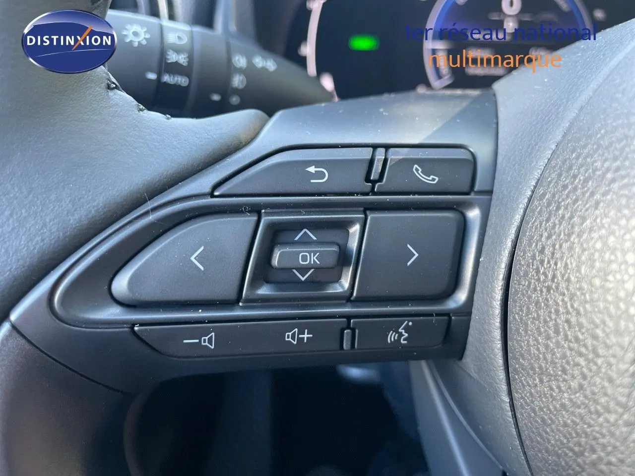 Gros plan sur les commandes au volant noir de la Toyota Yaris Hybrid 116ch 2025, avec boutons multifonctions.