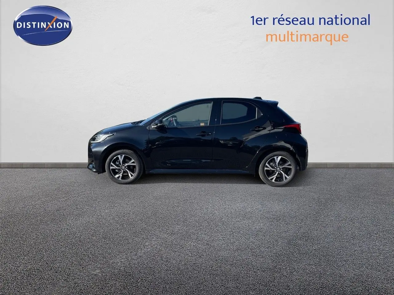 Profil latéral droit de la Toyota Yaris Hybrid 116ch Design 2025 en noir métal avec jantes alliage bicolores.