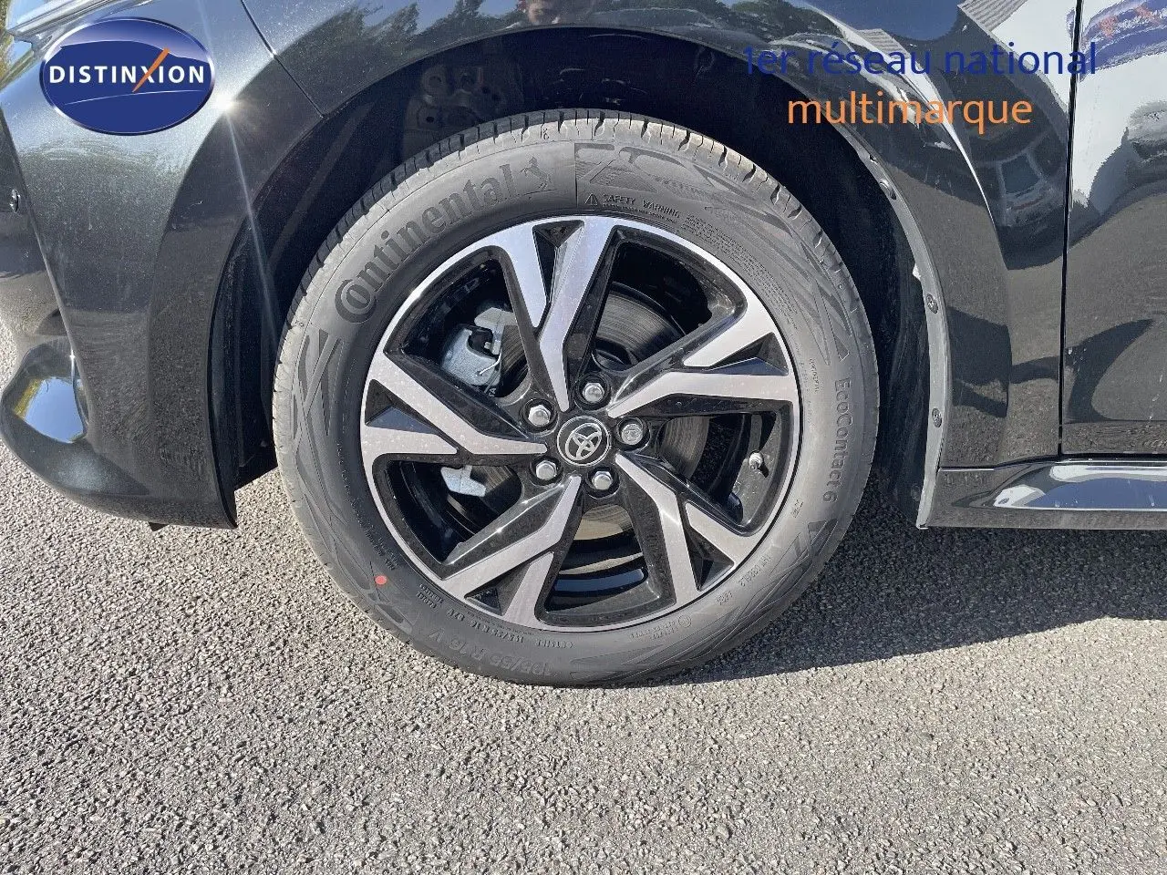 Gros plan sur la roue avant gauche noire métal d'une Toyota Yaris Hybrid 116ch 2025 avec jante alliage bicolore.