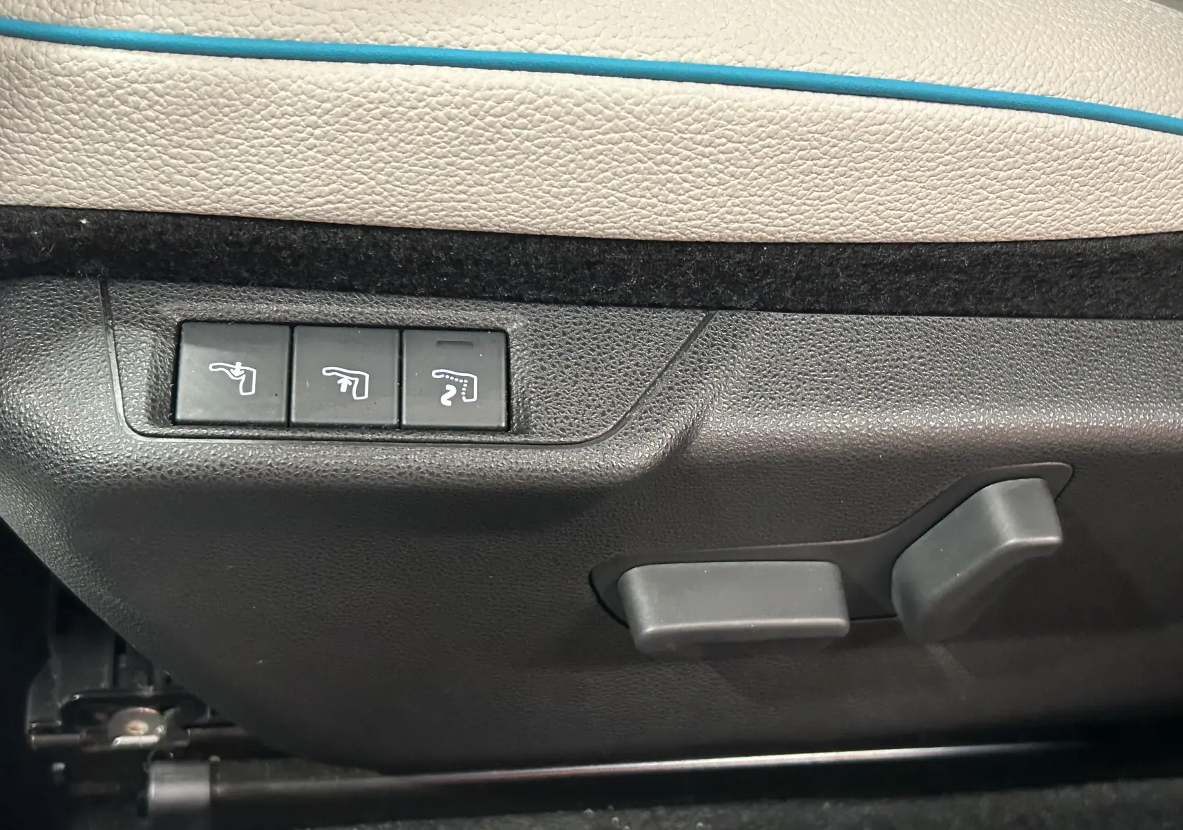 Commandes de réglage électrique des sièges sur la porte intérieure beige et bleu d'une FIAT 600 Hybrid 2024.