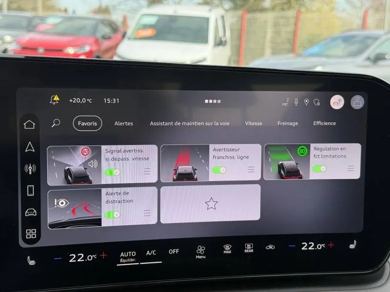 Écran tactile intérieur de l’Audi Q3 2026 montrant les aides à la conduite et la température à 22°C.