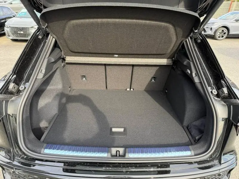 Coffre ouvert vu de l'arrière d'un Audi Q3 2026 noir Mythique métallisé, montrant un espace de chargement propre et spacieux.