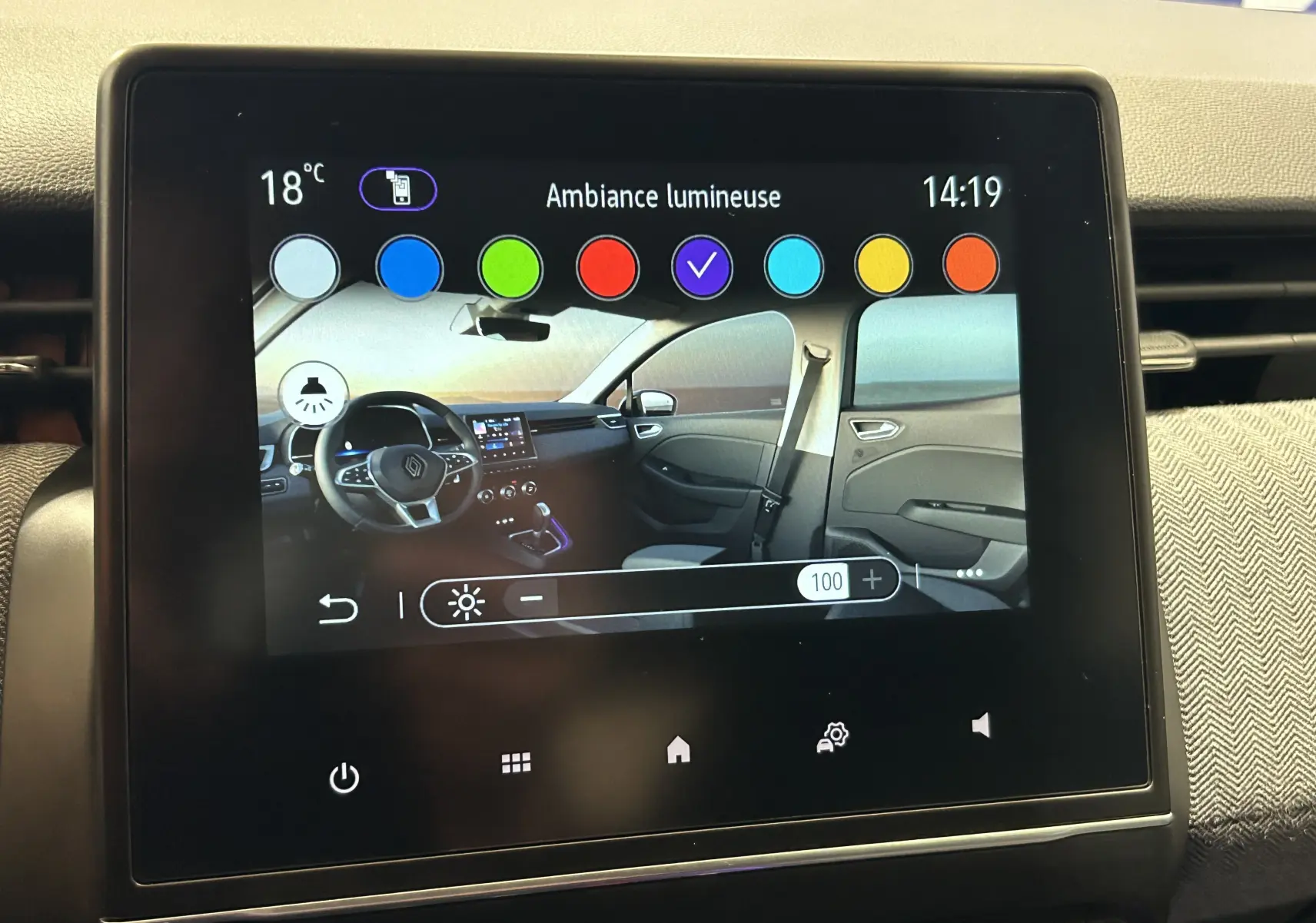 Écran tactile affichant l'intérieur côté droit de la Renault Clio V bleu iron metal avec ambiance lumineuse personnalisable.