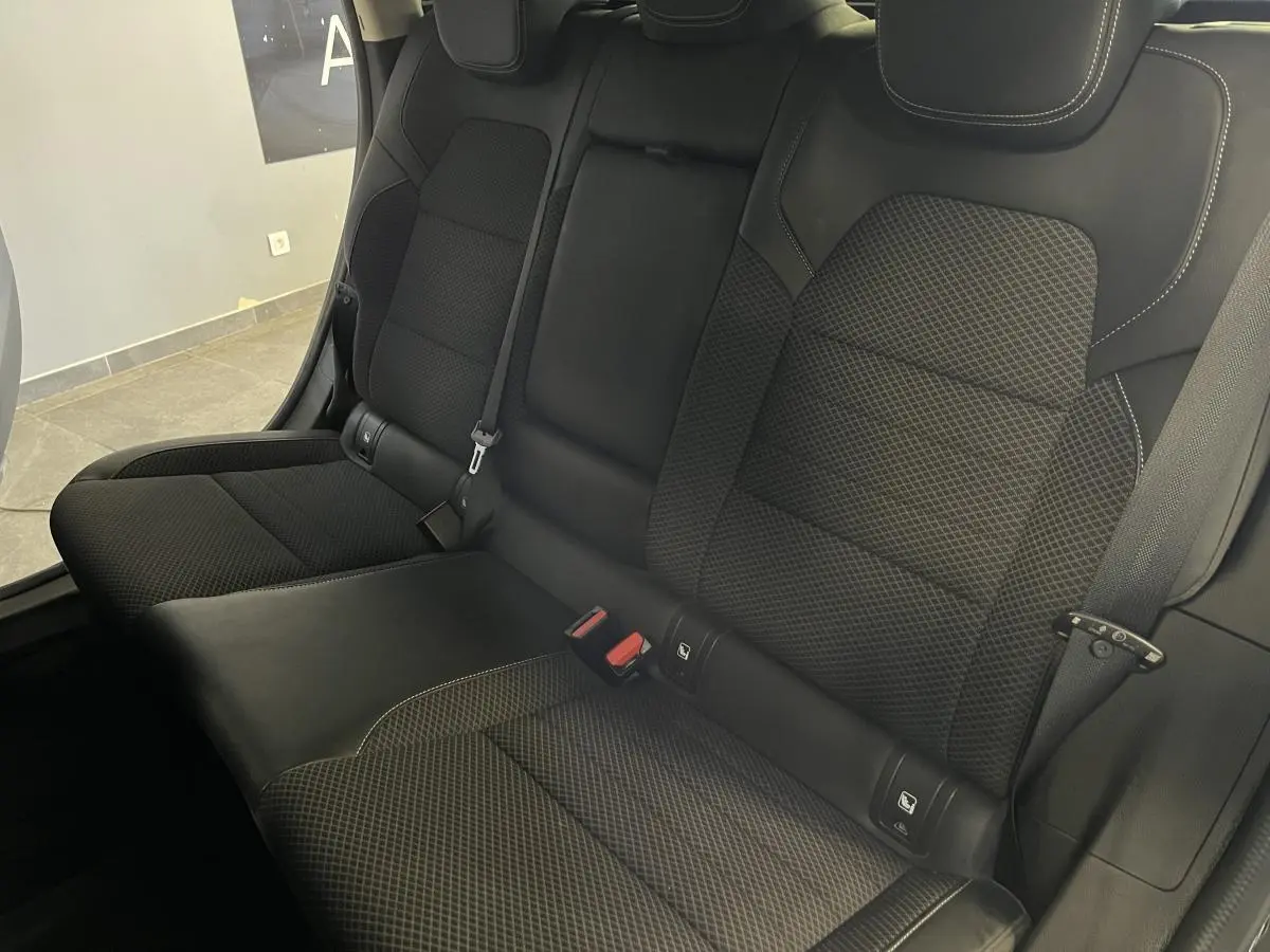 Vue rapprochée de la banquette arrière en tissu et similicuir noir du Renault Arkana 2021 avec ceintures et appuie-têtes intégrés.