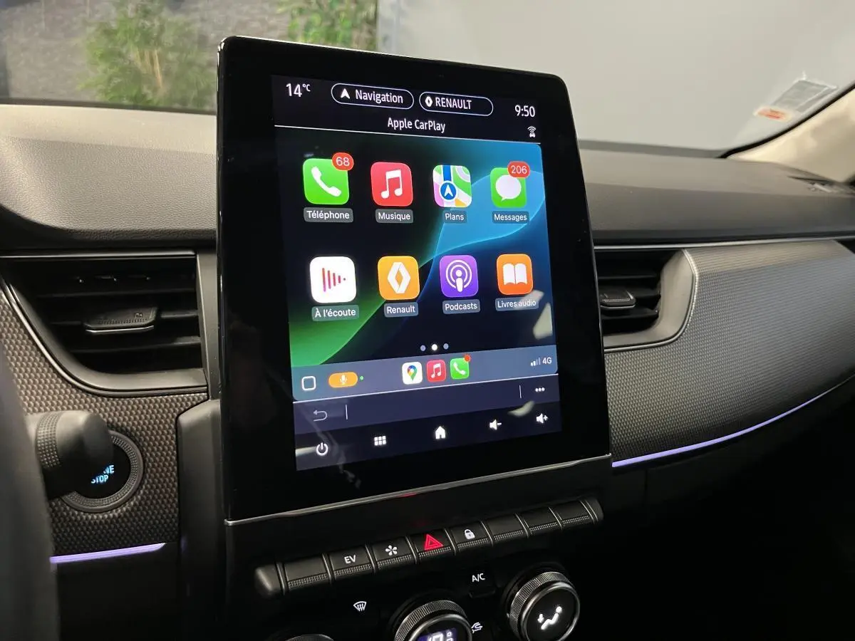 Écran tactile vertical du système multimédia Apple CarPlay dans le tableau de bord noir du Renault Arkana 2021.