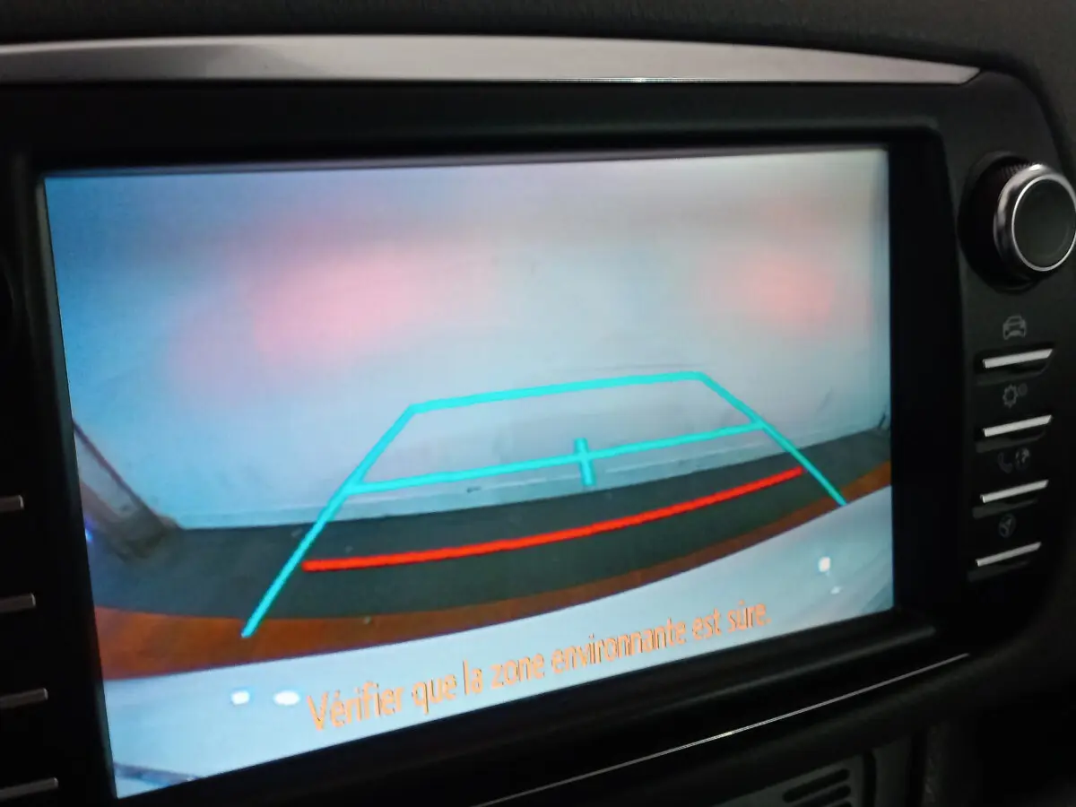 Affichage de la caméra de recul de la Toyota Yaris hybride blanche, vue arrière avec lignes de guidage colorées sur écran tactile.