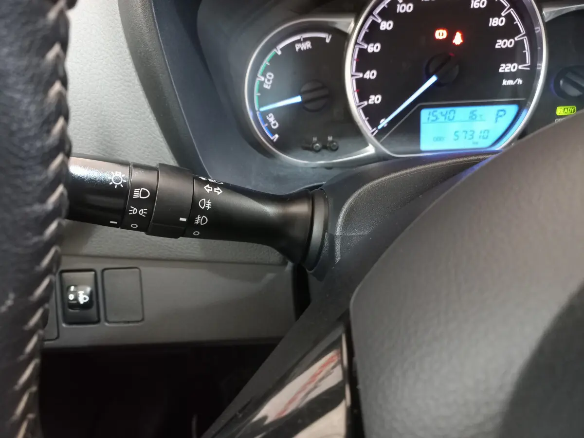 Vue rapprochée du tableau de bord de la Toyota Yaris hybride 2019, montrant le compteur et le commodo d'éclairage noir.