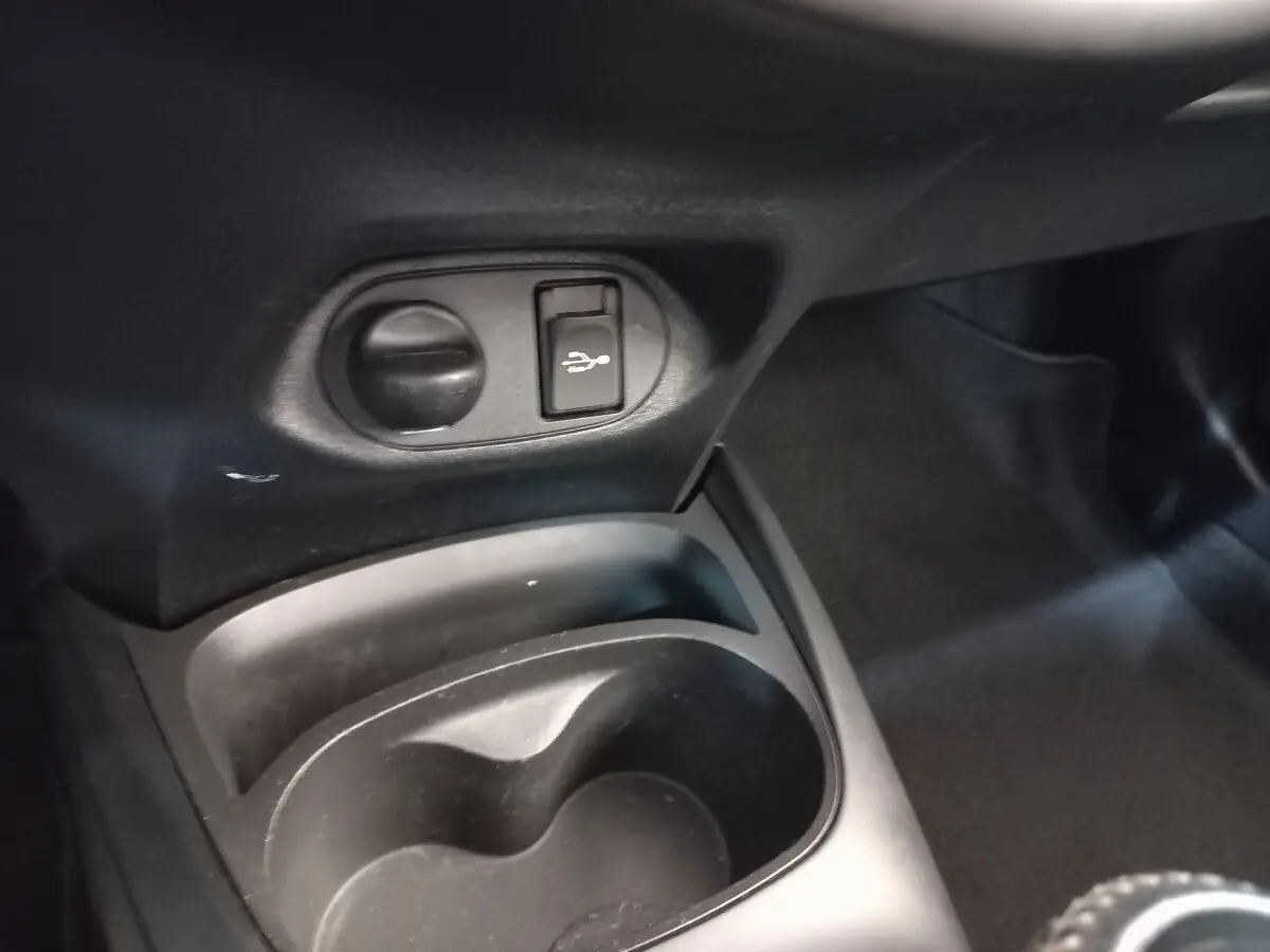 Gros plan sur la console centrale noire de la Toyota Yaris 2019, avec prise USB et allume-cigare visible.