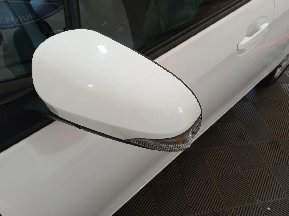 Rétroviseur côté gauche blanc avec clignotant intégré sur Toyota Yaris hybride 2019 vue rapprochée du côté conducteur.