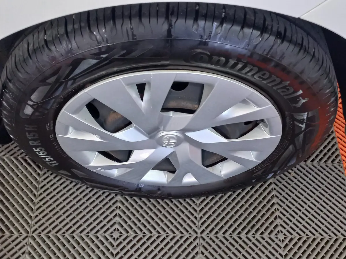 Gros plan sur la roue avant droite de la Toyota Yaris blanche, avec jante argentée et pneu Continental visible.
