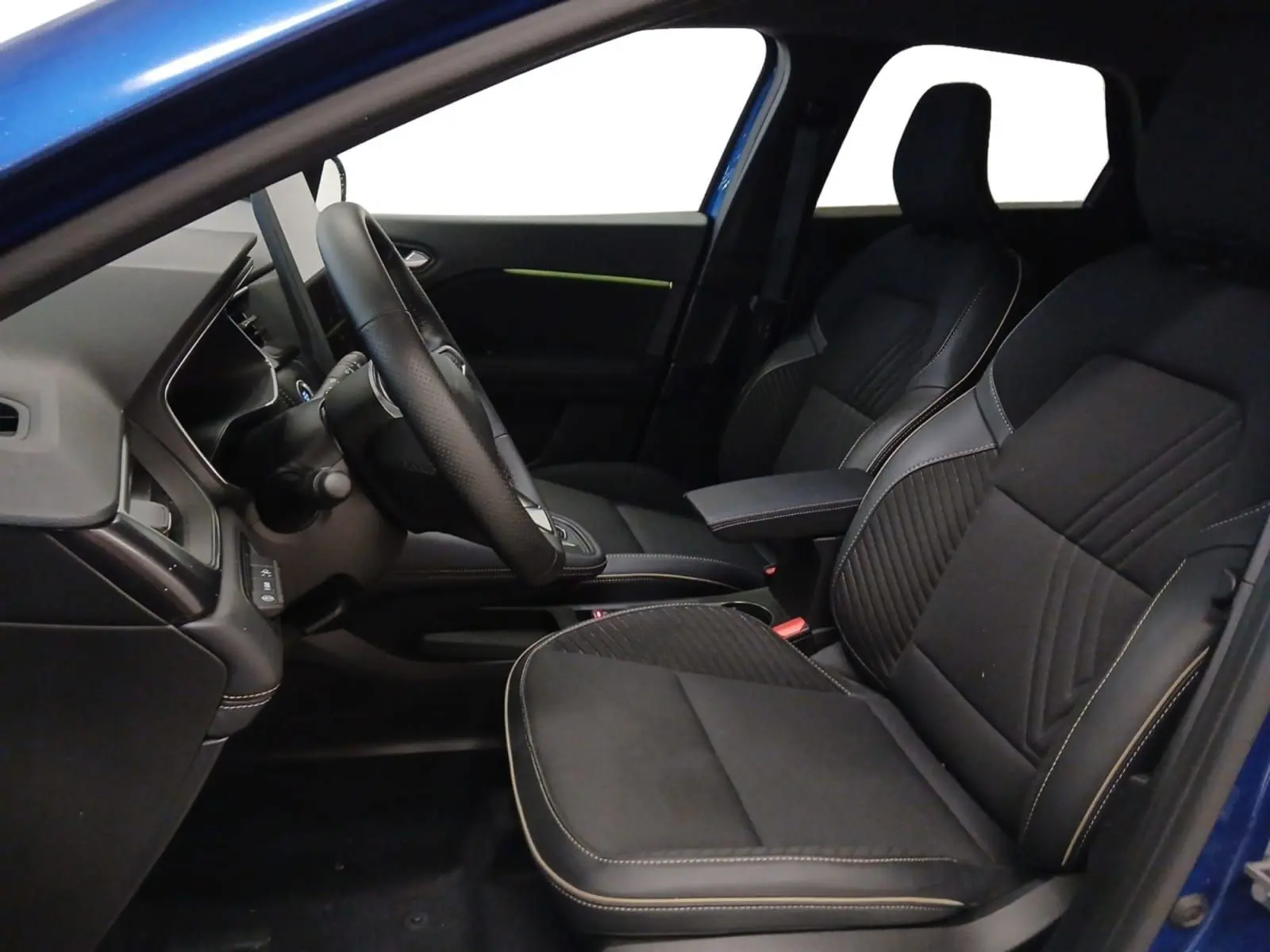 Vue intérieure côté conducteur du Renault Symbioz E-Tech Full Hybrid 145 Iconic 2025 en bleu Iron, sièges noirs avec surpiqûres contrastées.