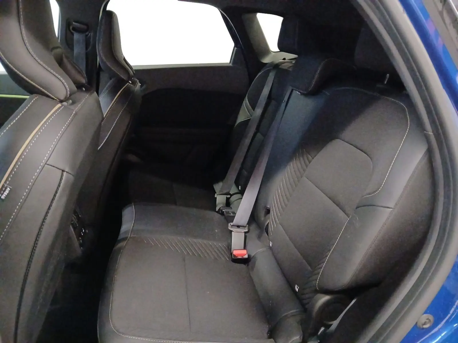 Vue intérieure côté droit des sièges arrière noirs avec surpiqûres contrastantes du Renault Symbioz Bleu Iron 2025 hybride.