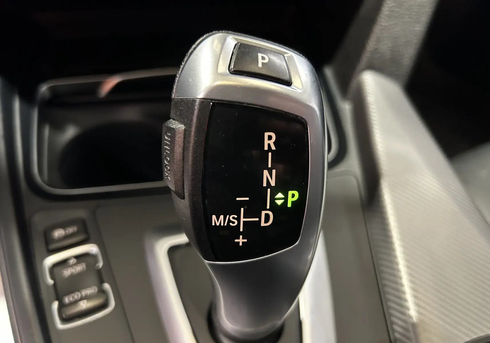 Le levier de vitesses automatique de la BMW Série 3 320i 2018 en gros plan avec indication mode parking verte.