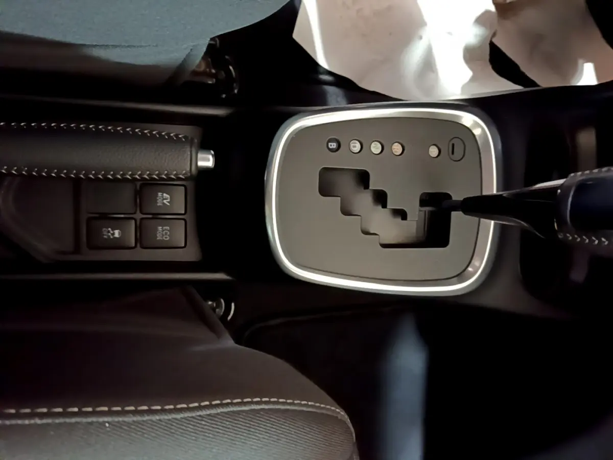 Gros plan sur la console centrale noire de la Toyota Yaris 1.5 Hybride 2020, montrant la boîte auto et les boutons de mode de conduite.