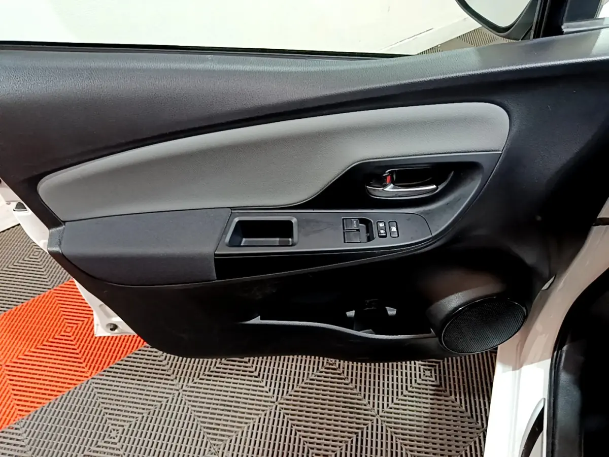 Porte avant droite de Toyota Yaris blanche 2020, avec commandes électriques et poignée intérieure noire.