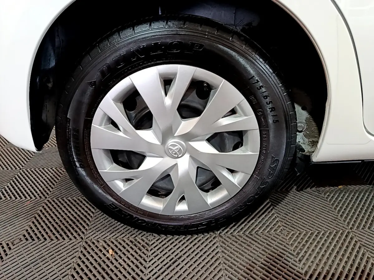 Gros plan sur la roue avant droite blanche d'une Toyota Yaris 1.5 Hybride 2020 avec enjoliveur argenté au design moderne.