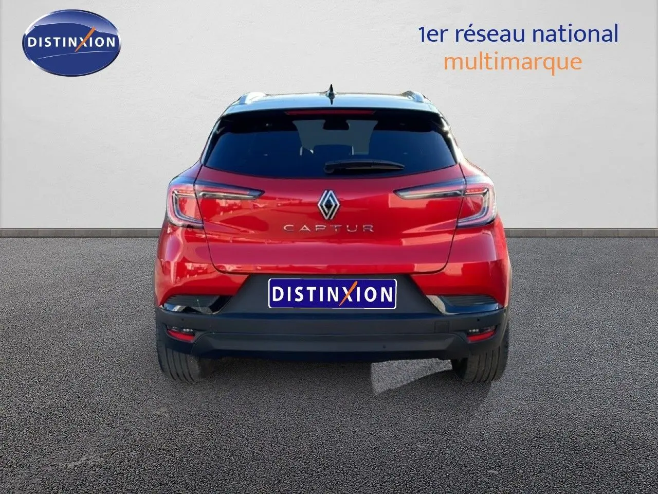 Vue arrière d'un Renault Captur rouge Désir métal avec toit noir, affichant ses feux LED et logo central.